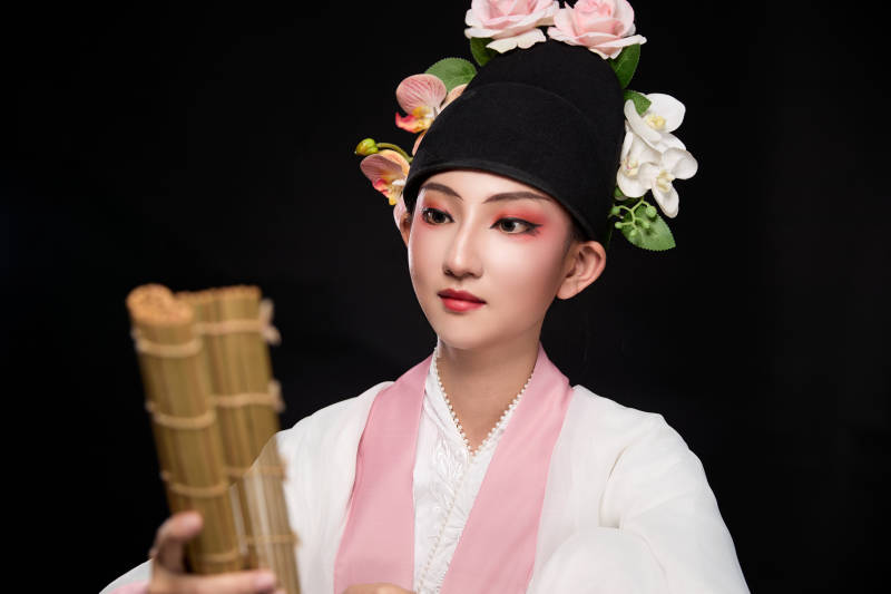 身着粤剧戏曲反串装扮手持竹简的青年女性图片
