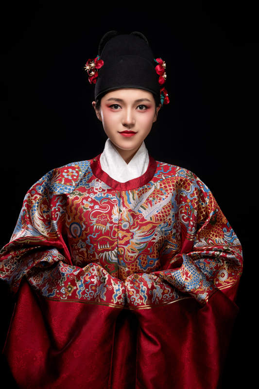 黑色背景下身着明代飞鱼服的青年女性图片