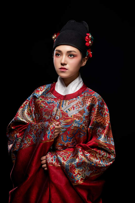 黑色背景下身着明代飞鱼服的青年女性图片