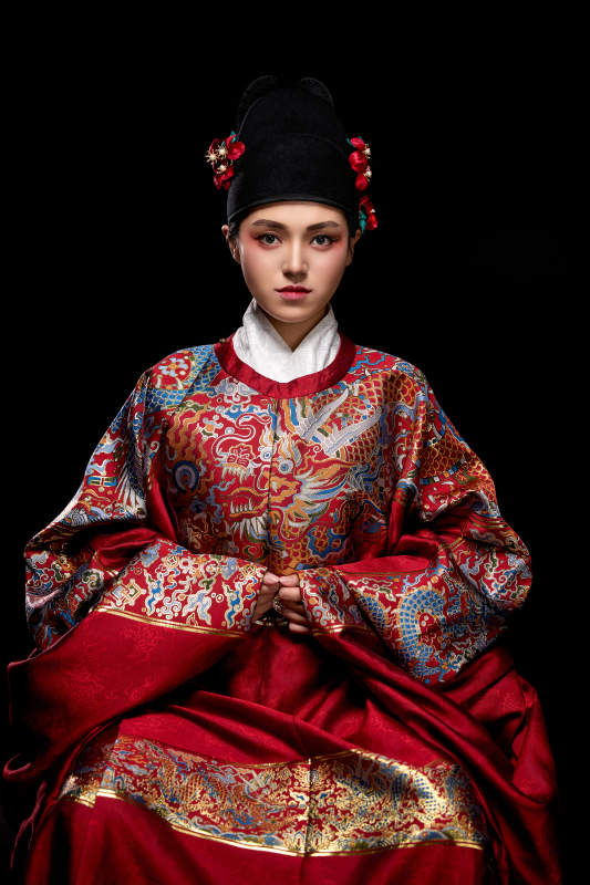 黑色背景下身着明代飞鱼服的青年女性图片