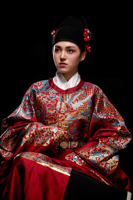 黑色背景下身着明代飞鱼服的青年女性图片