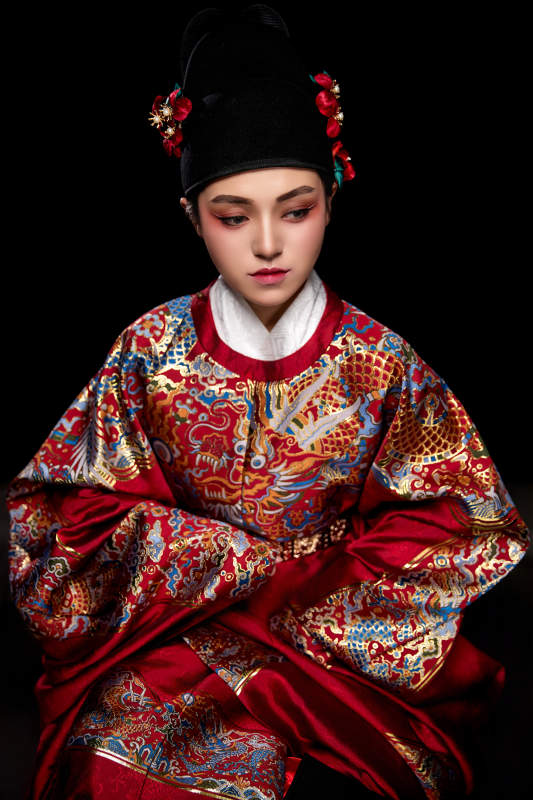 黑色背景下身着明代飞鱼服的青年女性图片