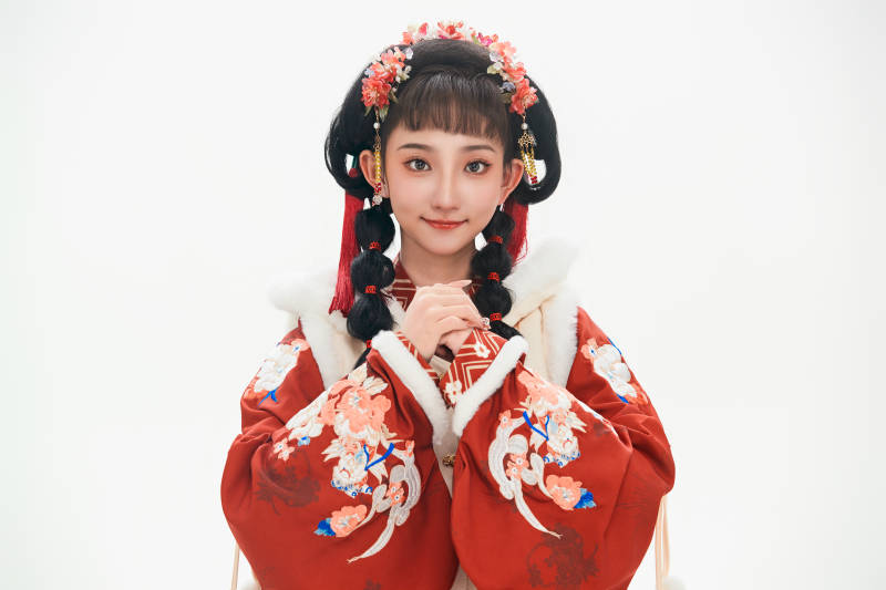 白色背景下身穿喜庆中式汉服的可爱少女图片