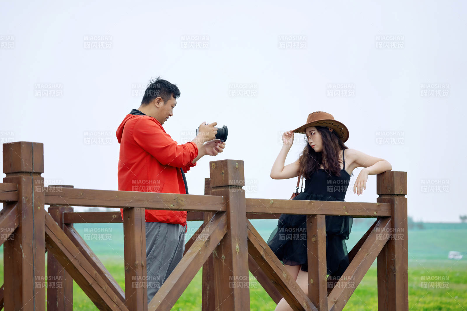 夏天在草原景区拍照的摄影师与模特图片