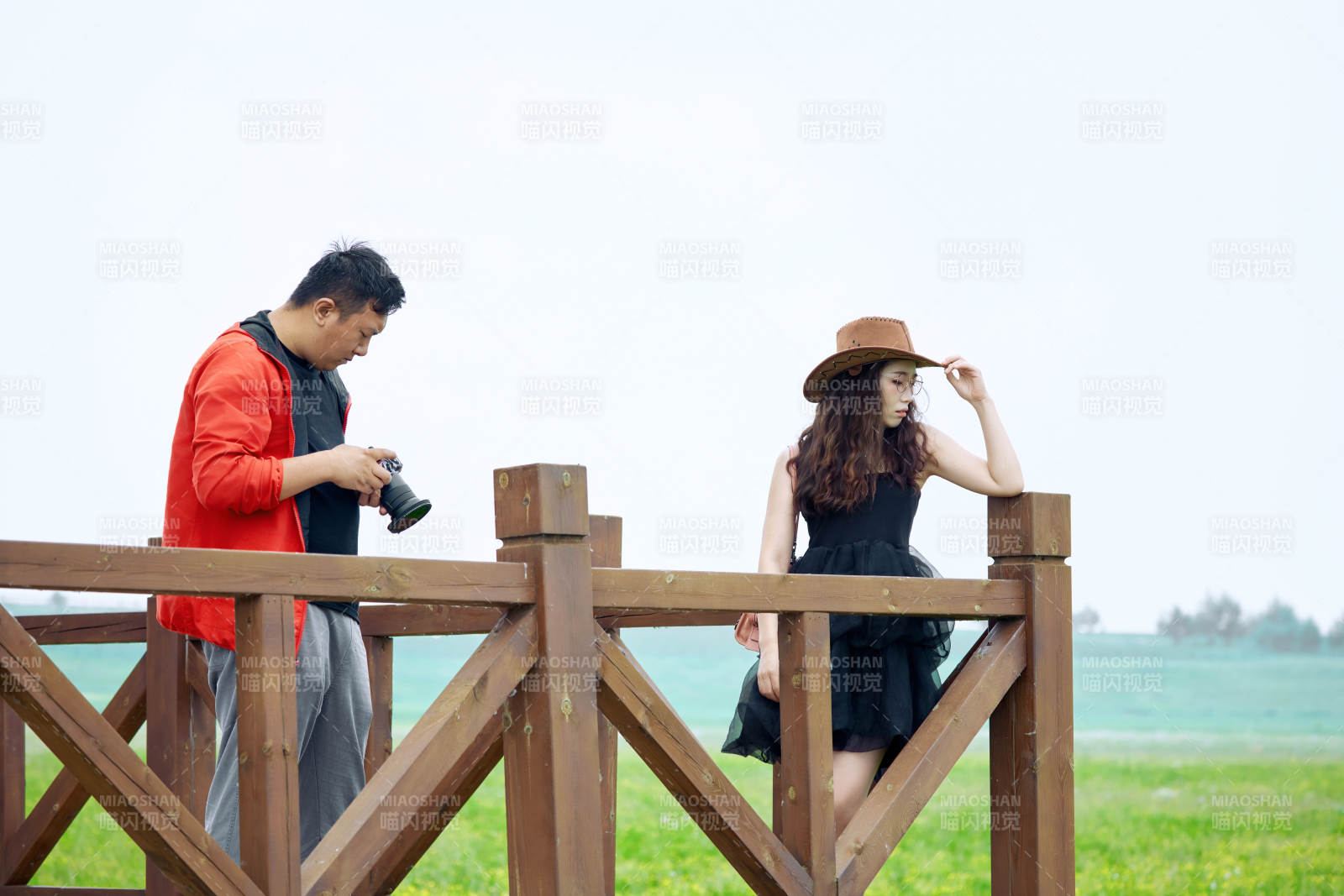 夏天在草原景区拍照的摄影师与模特图片