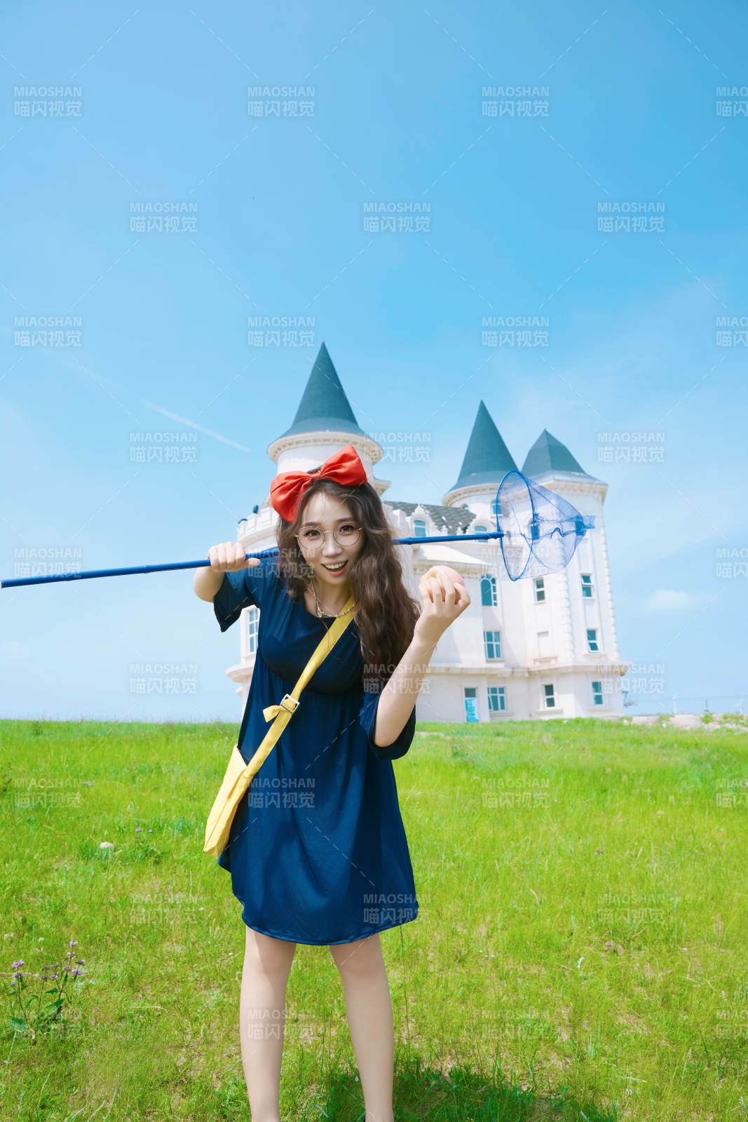 身穿小魔女服饰在城堡前拍照打卡的亚洲美女图片