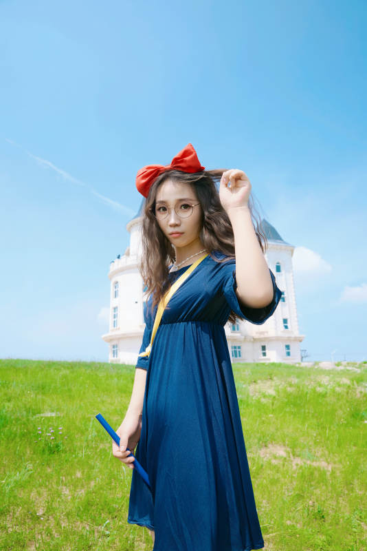 身穿小魔女服饰在城堡前拍照打卡的亚洲美女图片