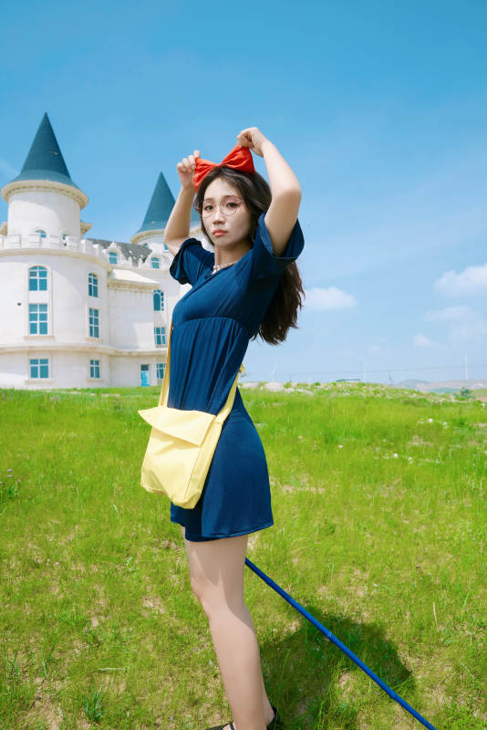 身穿小魔女服饰在城堡前拍照打卡的亚洲美女图片