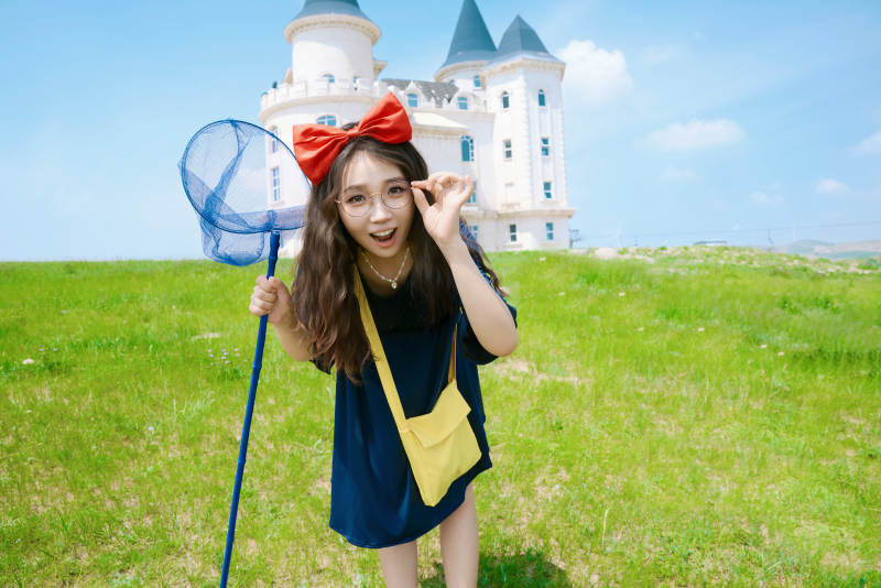 身穿小魔女服饰在城堡前拍照打卡的亚洲美女图片