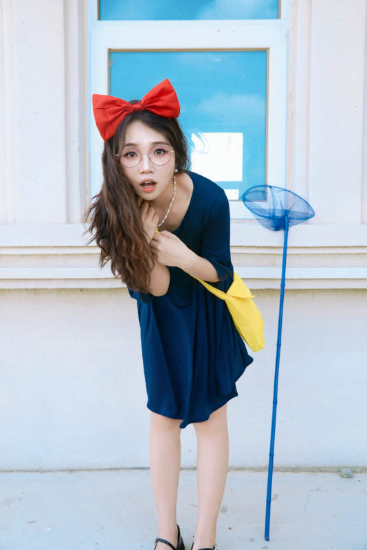 身穿小魔女服饰在城堡前拍照打卡的亚洲美女图片