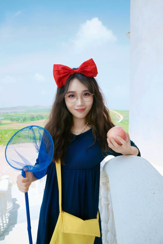 身穿小魔女服饰在城堡前拍照打卡的亚洲美女图片