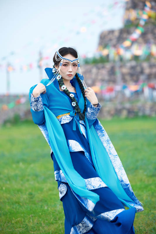 在草原穿着古风服饰拍照的亚洲美女图片