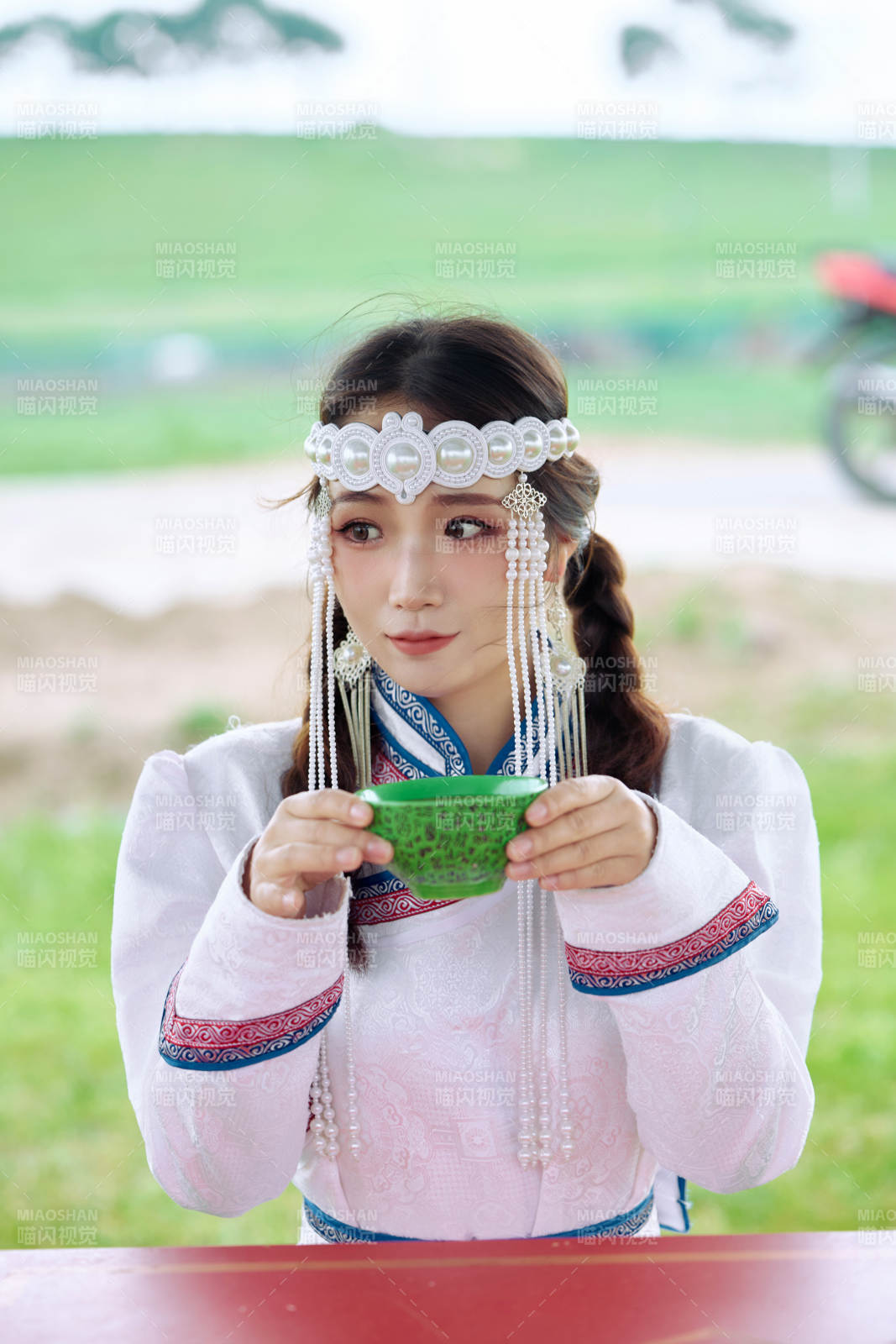 穿着蒙古族传统服饰品尝奶茶的亚洲美女图片