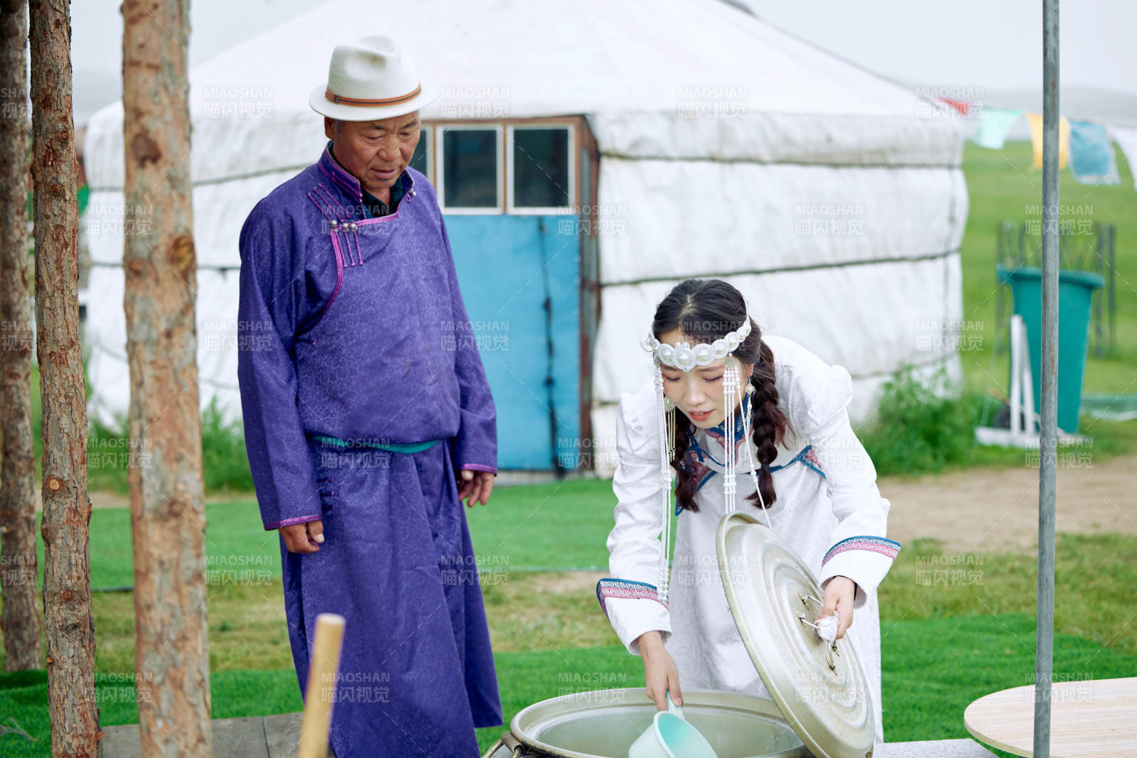 在蒙古包前为游客打奶茶的蒙古族父女图片