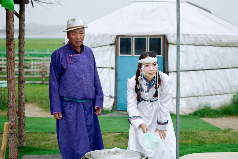 在蒙古包前为游客打奶茶的蒙古族父女图片