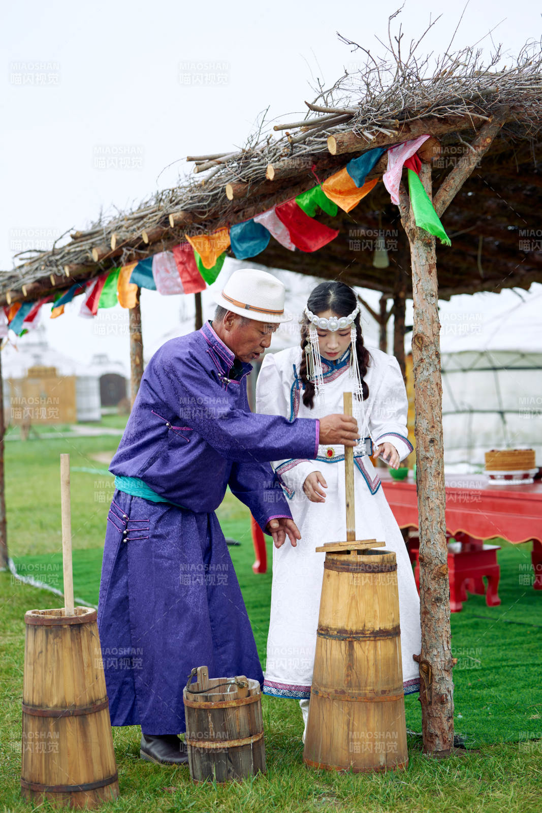 在蒙古包前为游客打奶茶的蒙古族父女图片