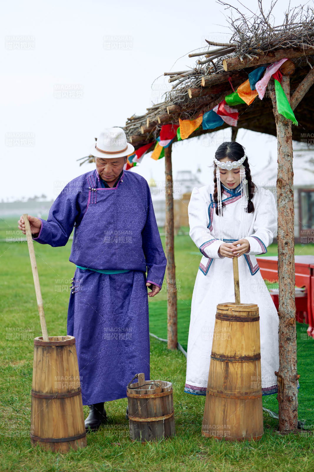 在蒙古包前为游客打奶茶的蒙古族父女图片