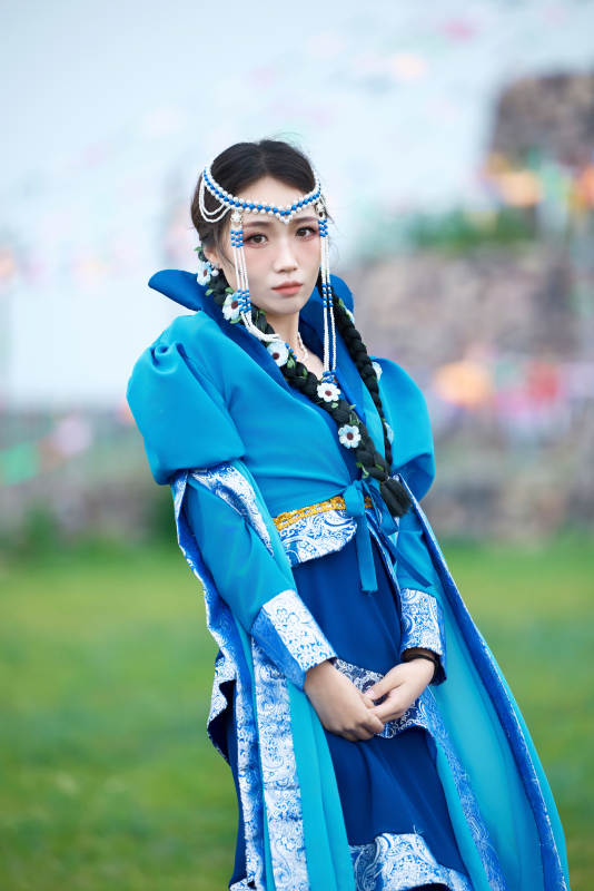 在草原穿着古风服饰拍照的亚洲美女图片