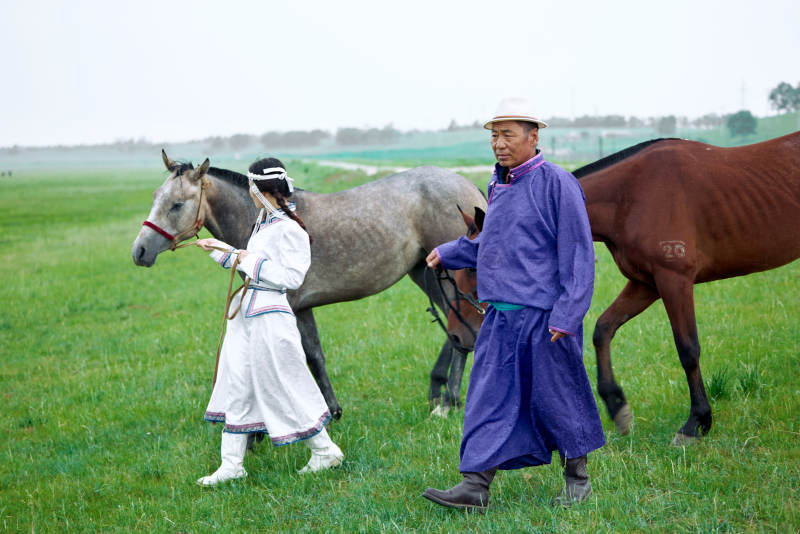 在草原放牧的蒙古族牧民父女图片
