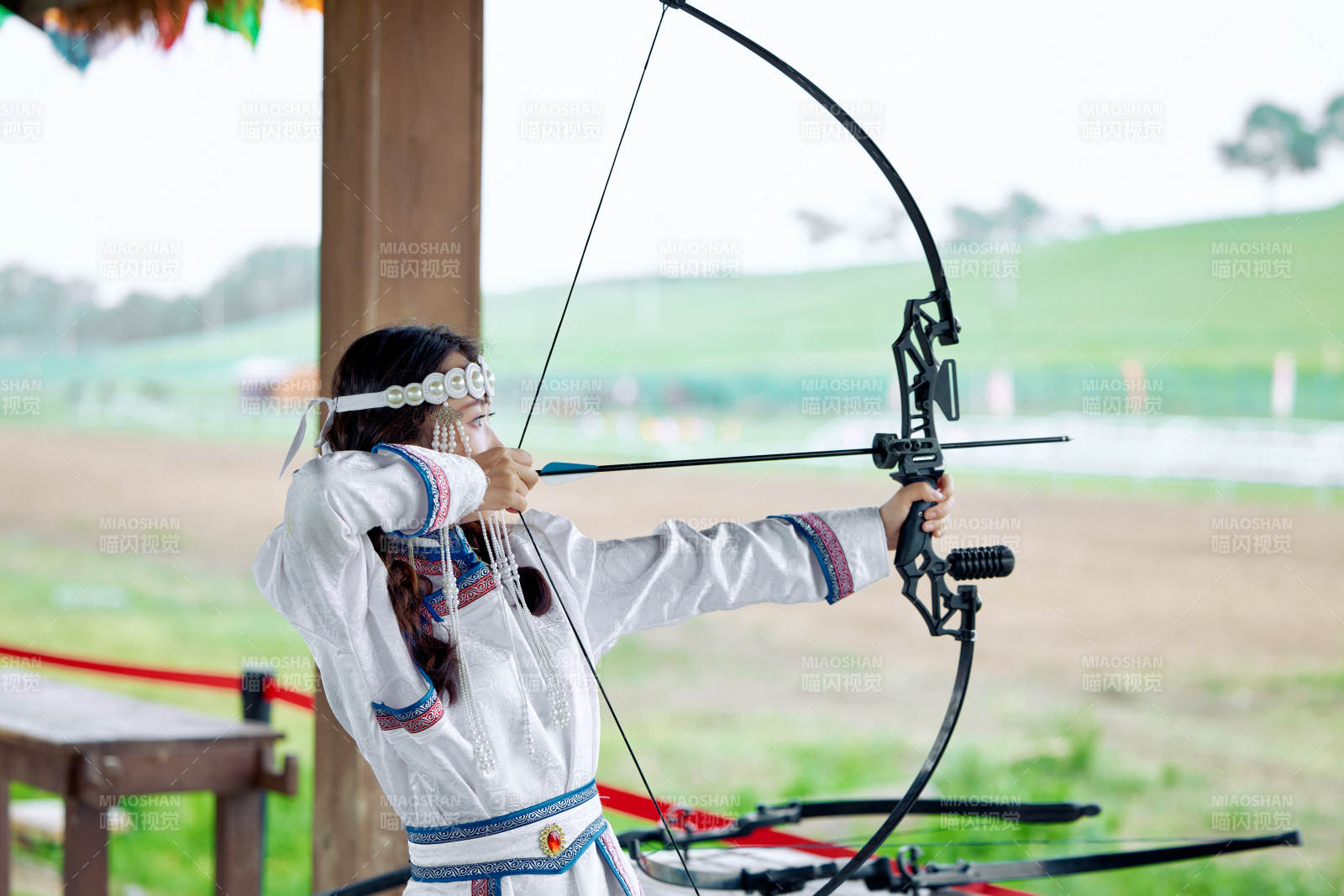 在草原景区靶场射箭的蒙古族美女图片