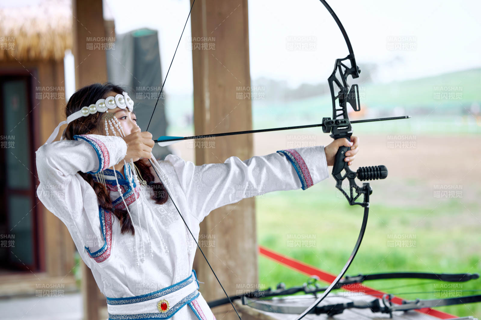 在草原景区靶场射箭的蒙古族美女图片