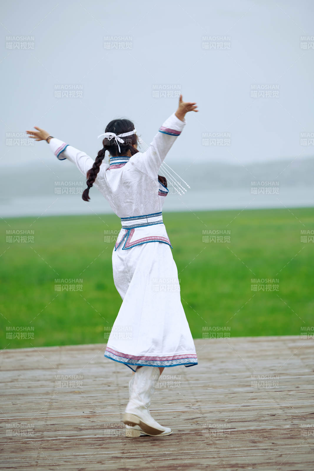 在草原穿着古风服饰拍照的亚洲美女图片