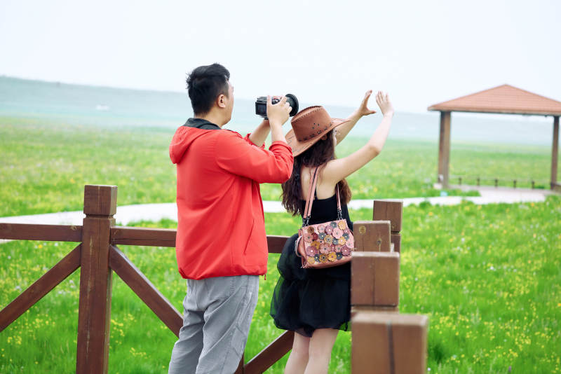 夏天在草原景区拍照的摄影师与模特图片