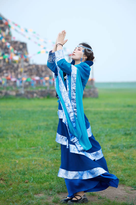 在草原穿着古风服饰拍照的亚洲美女图片