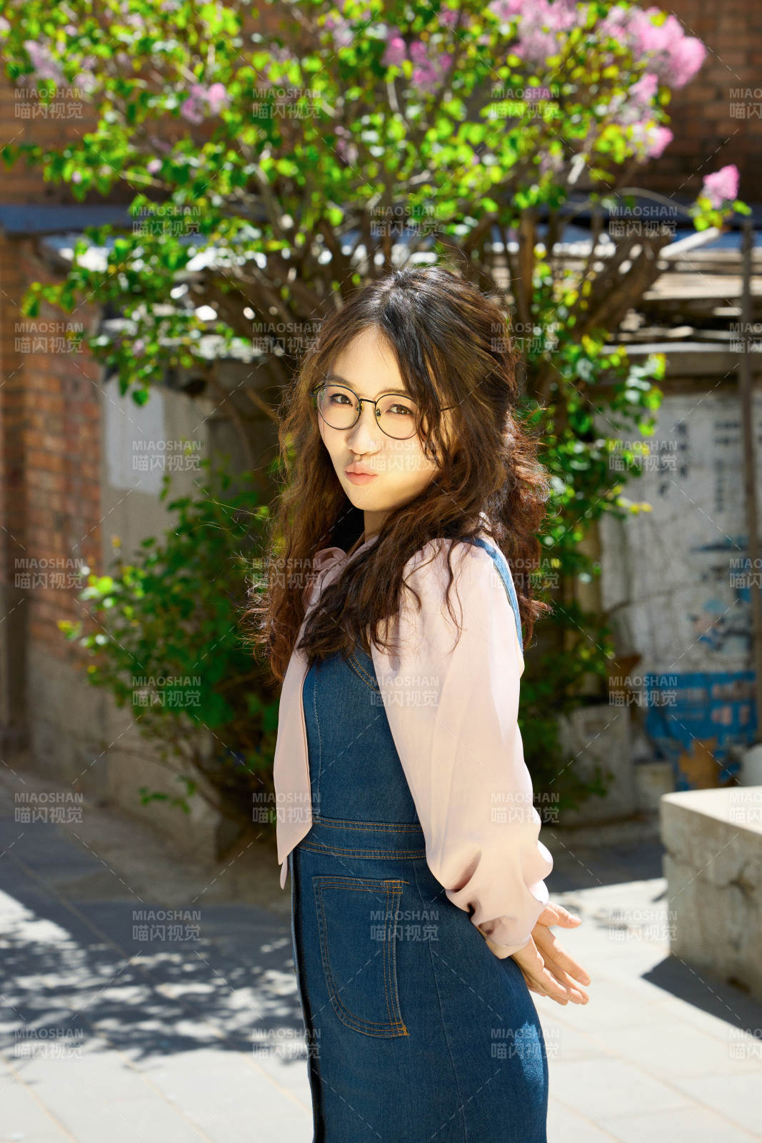 春天在梨花树下拍照的东方美女图片