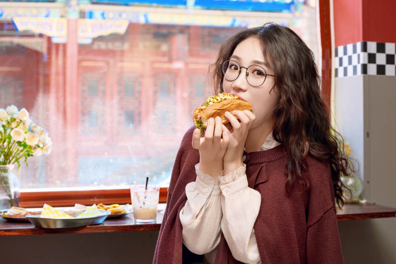 在没事热狗快餐店大吃特吃的东方女性图片