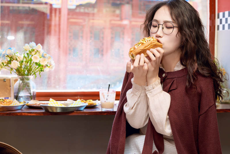 在没事热狗快餐店大吃特吃的东方女性图片