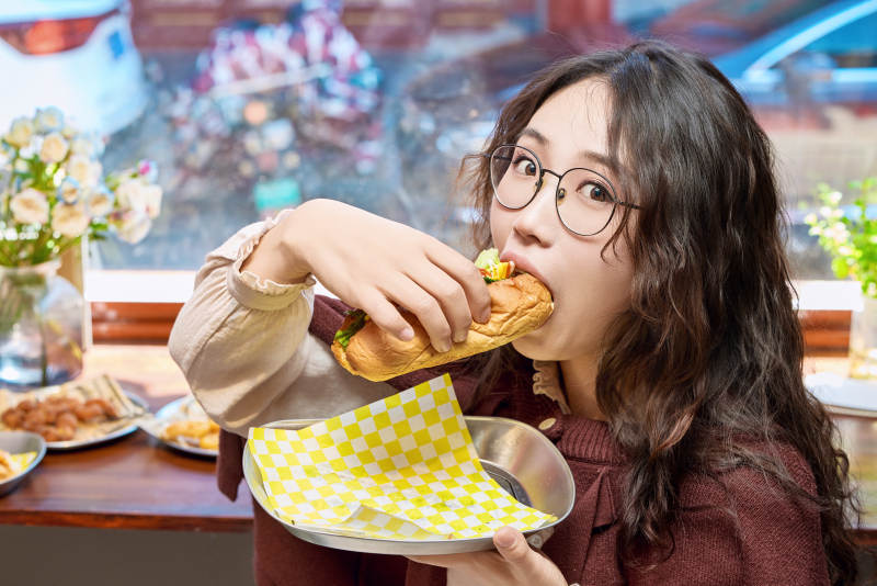 在没事热狗快餐店大吃特吃的东方女性图片