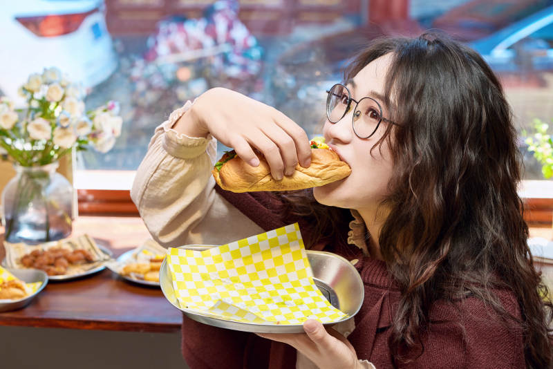 在没事热狗快餐店大吃特吃的东方女性图片