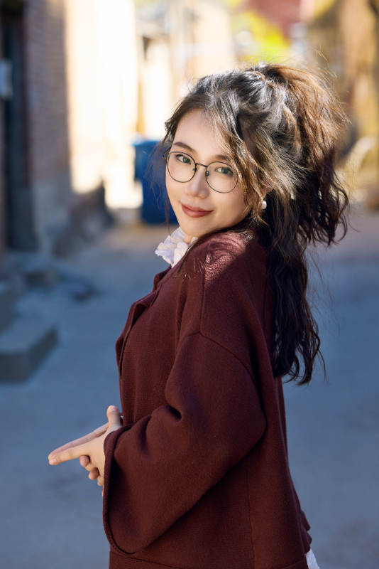 在老旧城区拍照游玩的东方美女图片