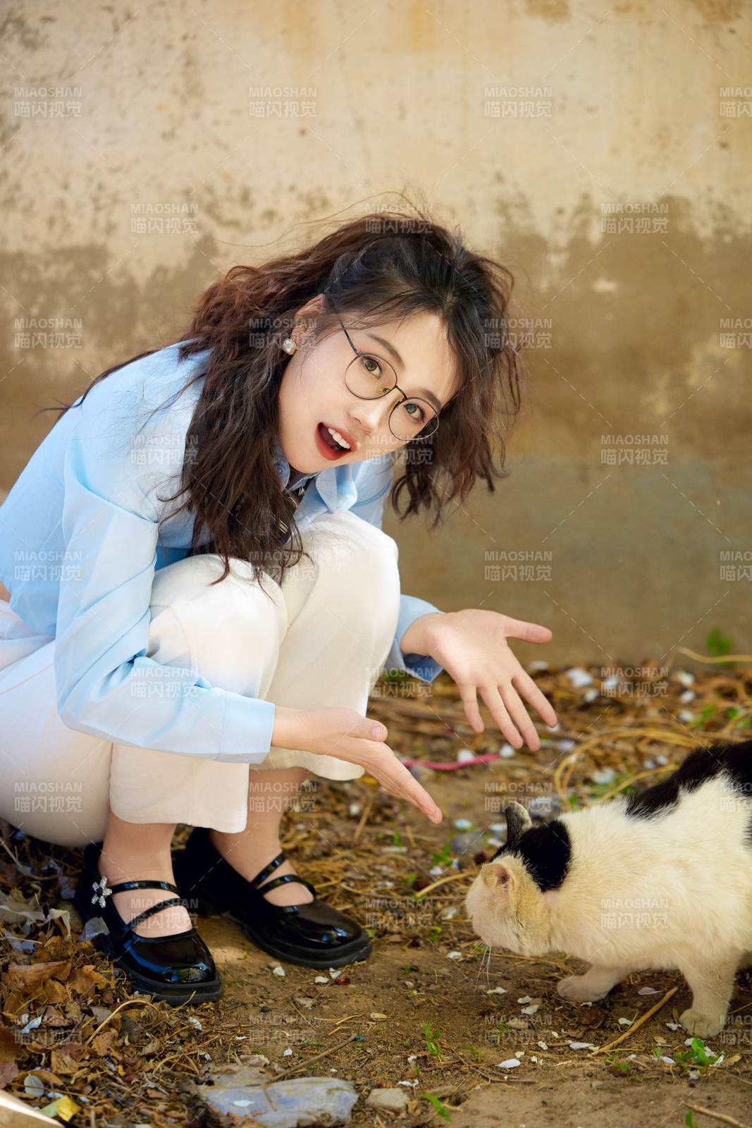 在小区里投喂流浪猫咪的东方女性图片