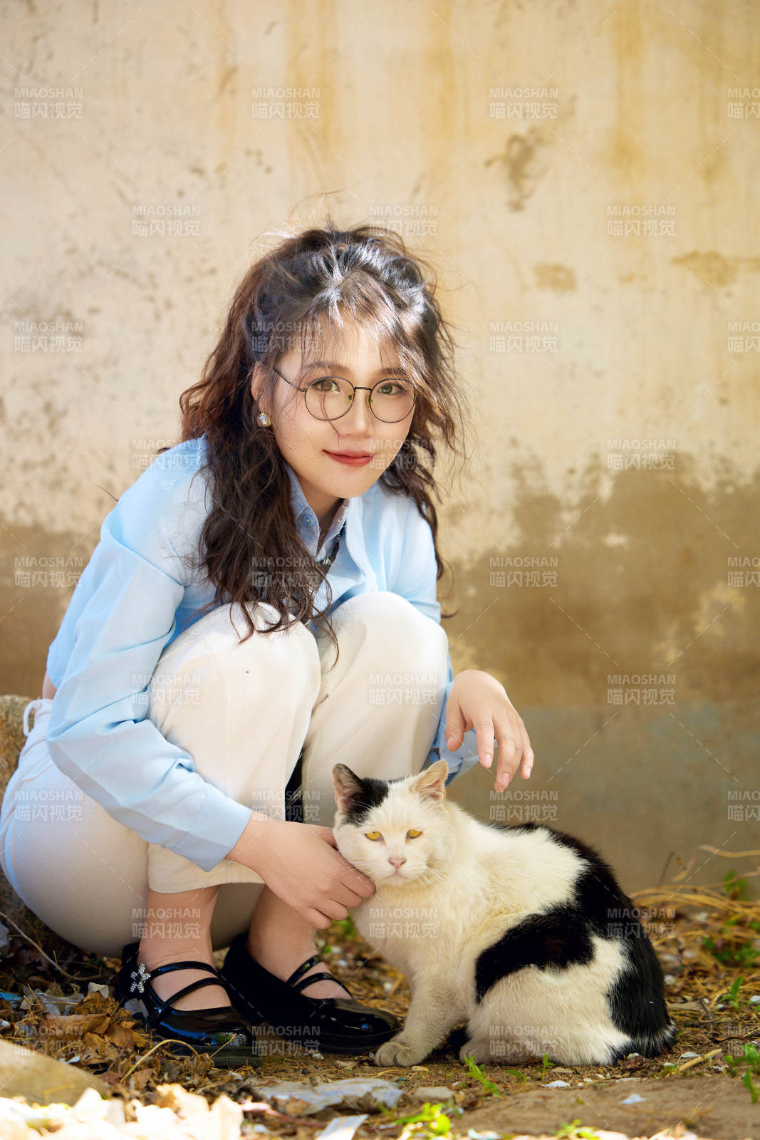 在小区里投喂流浪猫咪的东方女性图片