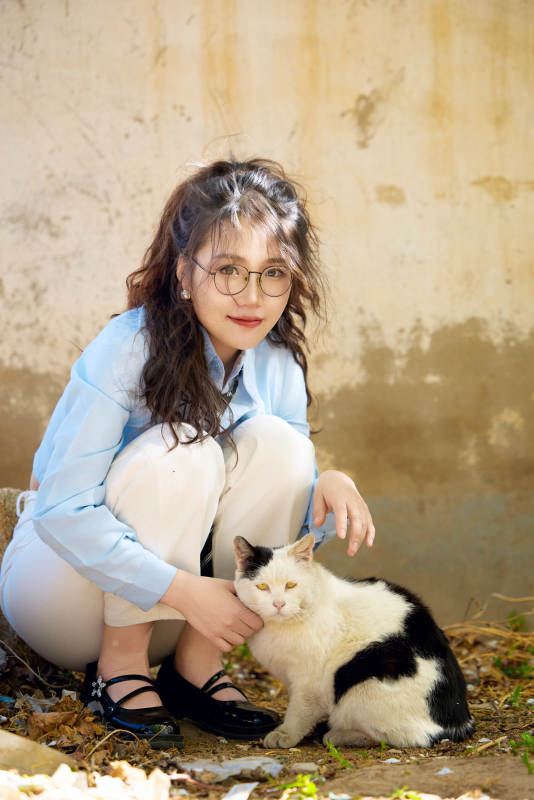 在小区里投喂流浪猫咪的东方女性图片