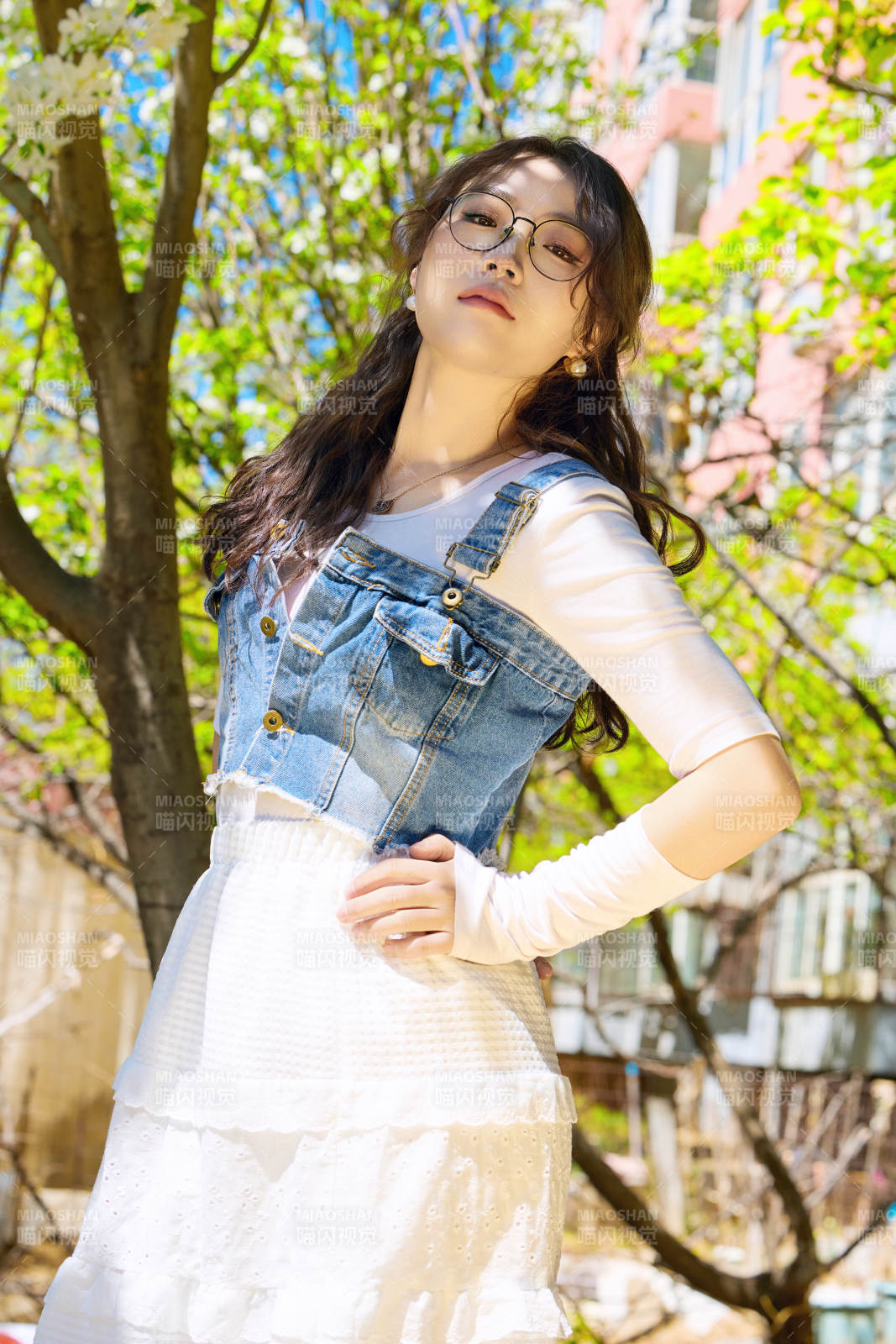 春天在梨花树下拍照的东方美女图片