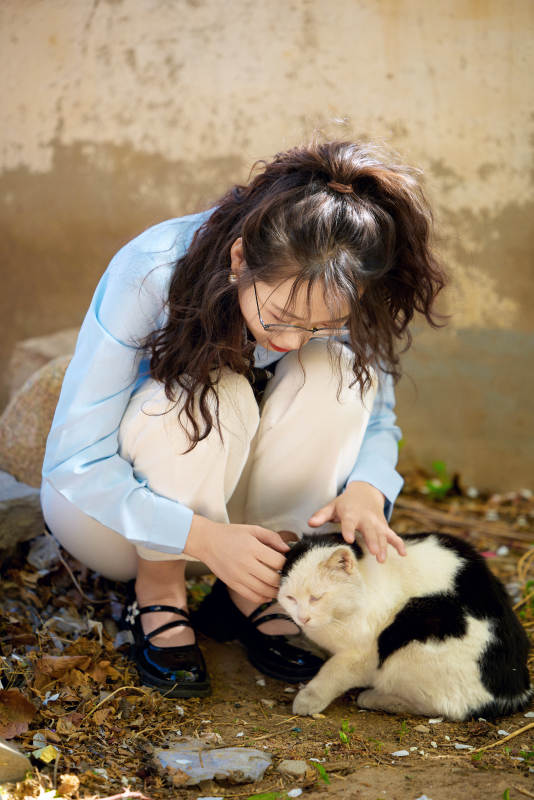 在小区里投喂流浪猫咪的东方女性图片