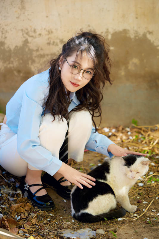 在小区里投喂流浪猫咪的东方女性图片