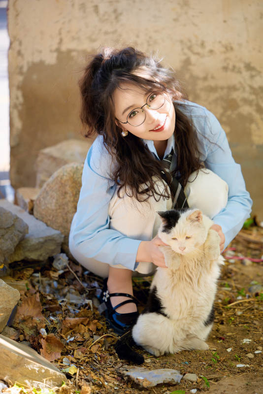 在小区里投喂流浪猫咪的东方女性图片