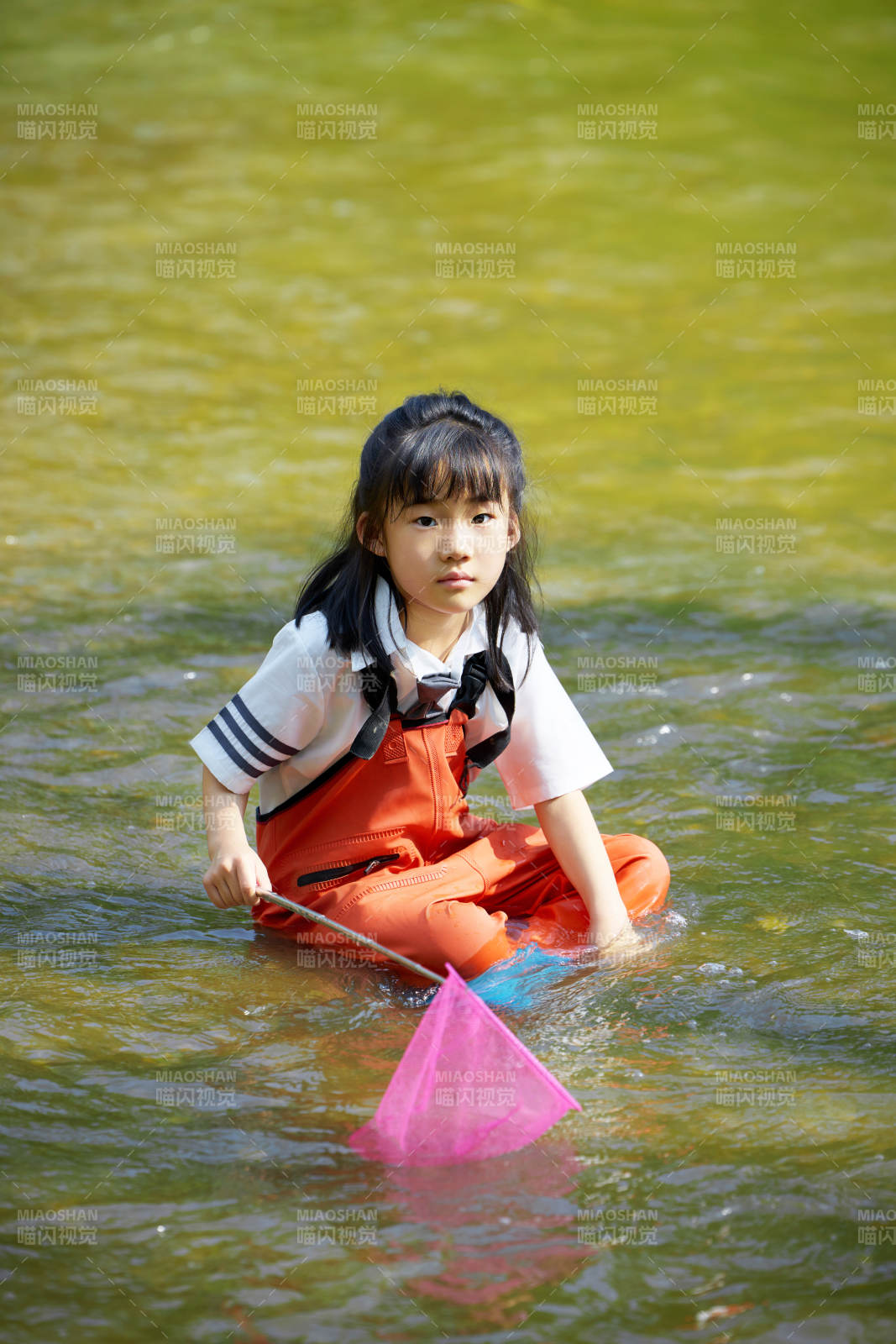 在溪流玩耍捕鱼的可爱亚洲女童图片