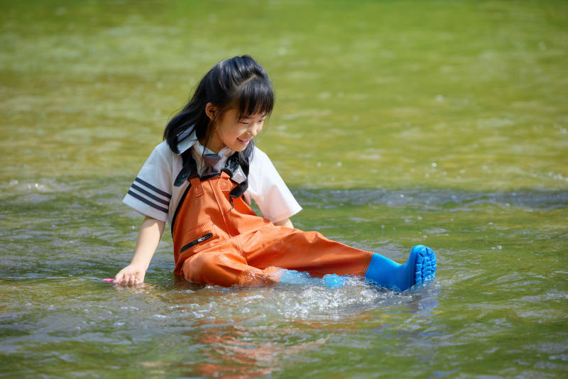 在溪流玩耍捕鱼的可爱亚洲女童图片