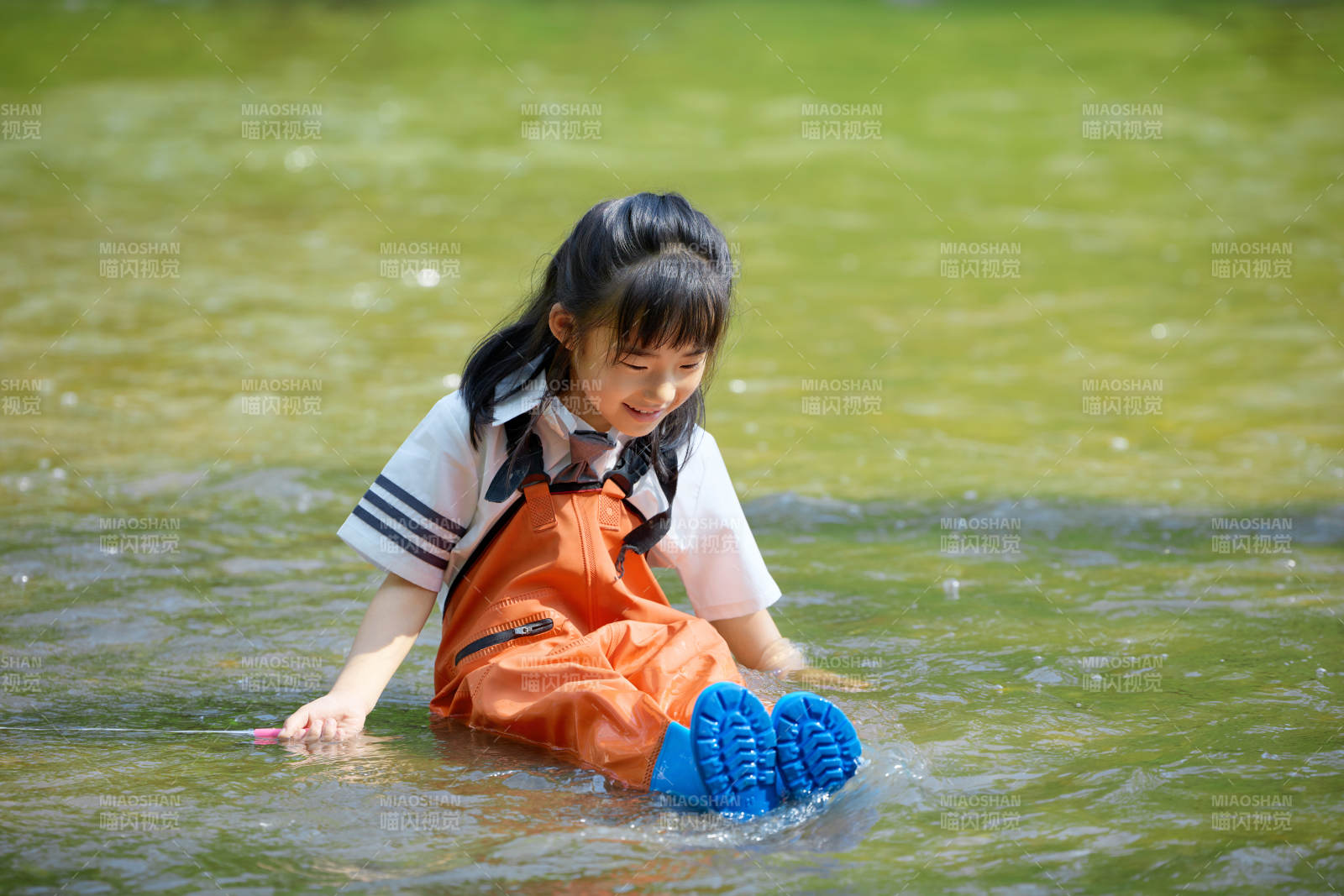 在溪流玩耍捕鱼的可爱亚洲女童图片