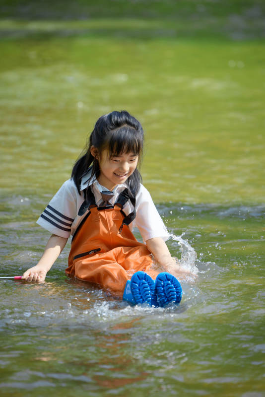 在溪流玩耍捕鱼的可爱亚洲女童图片