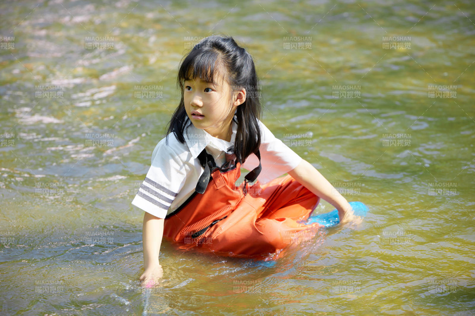 在溪流玩耍捕鱼的可爱亚洲女童图片