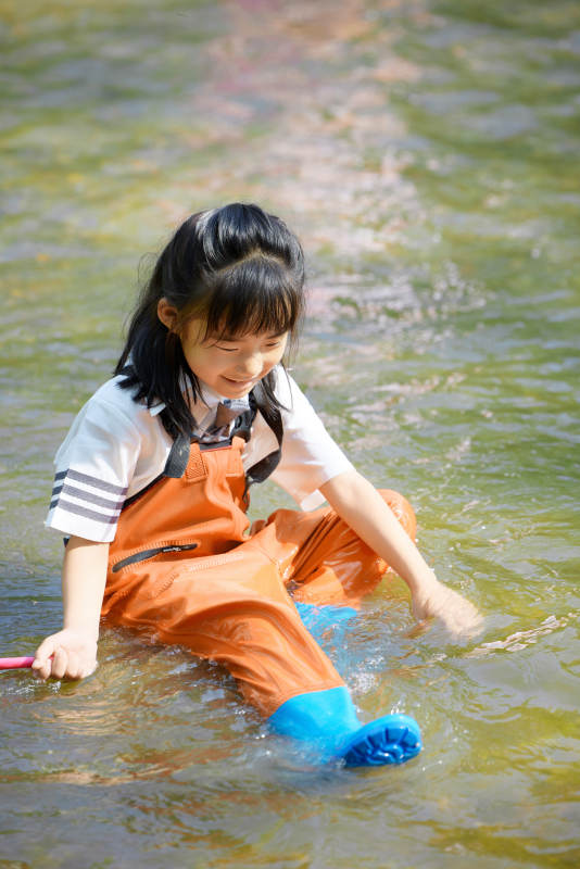 在溪流玩耍捕鱼的可爱亚洲女童图片