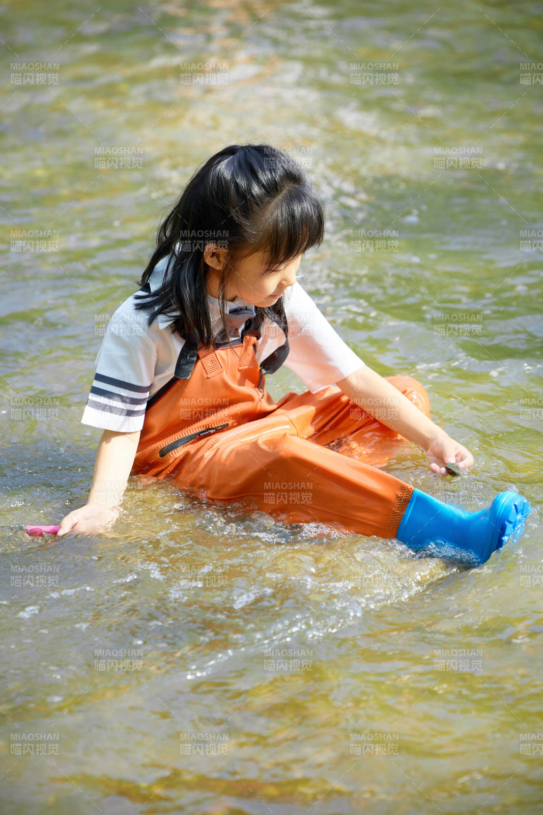 在溪流玩耍捕鱼的可爱亚洲女童图片