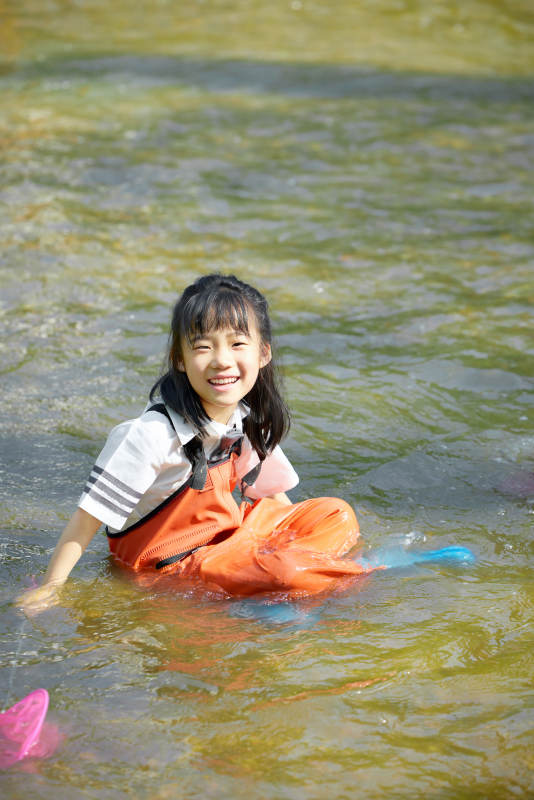 在溪流玩耍捕鱼的可爱亚洲女童图片
