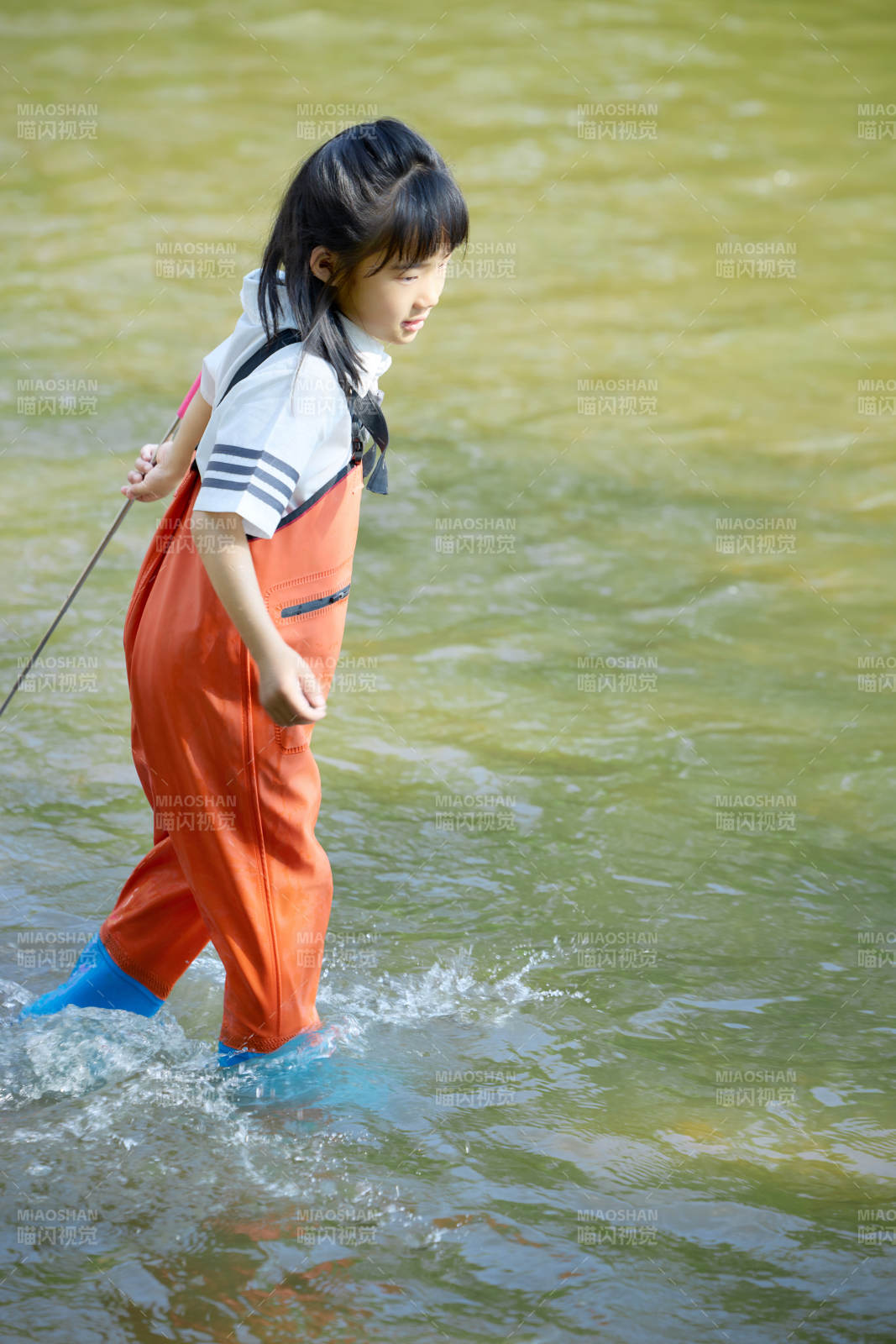 在溪流玩耍捕鱼的可爱亚洲女童图片